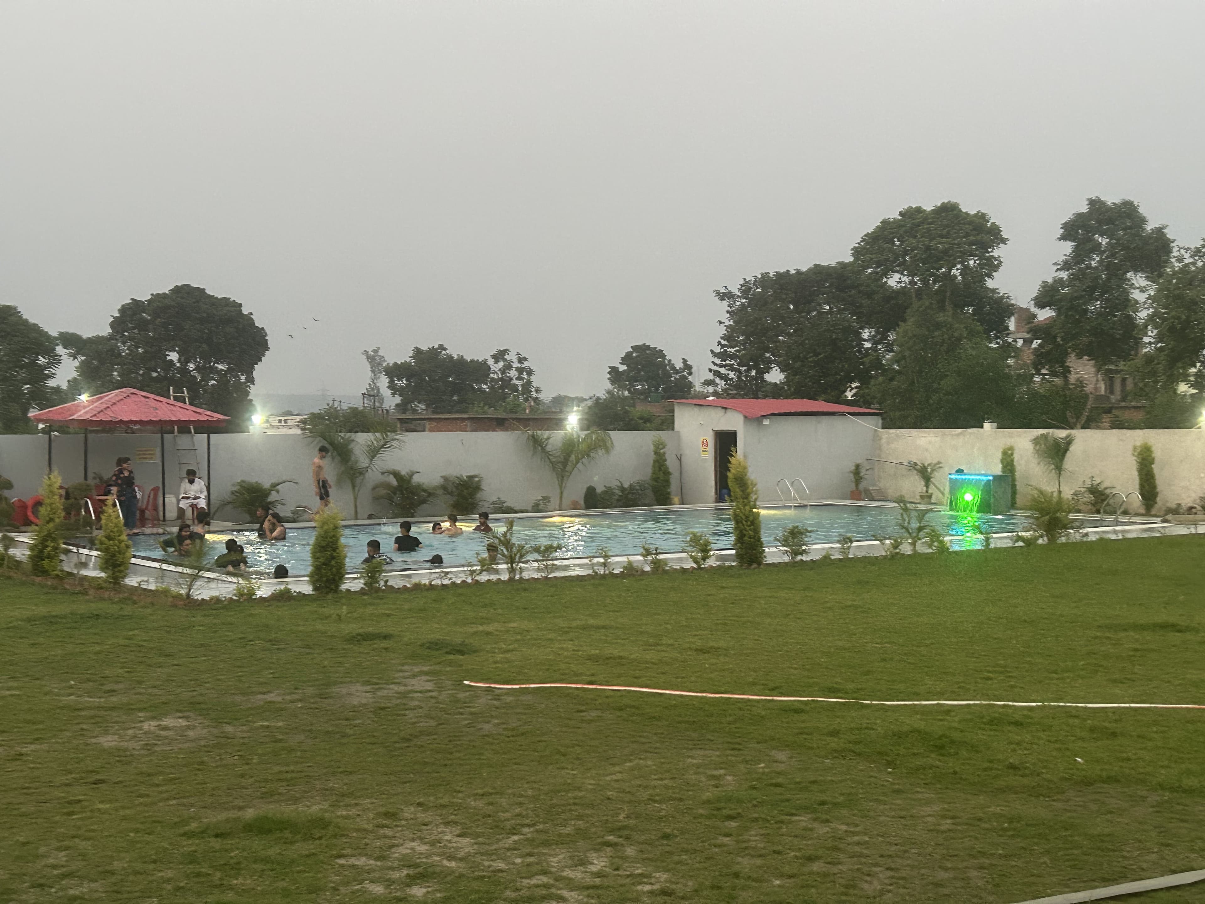 Daytime swimming pool and lawn view at resort in Dehradun